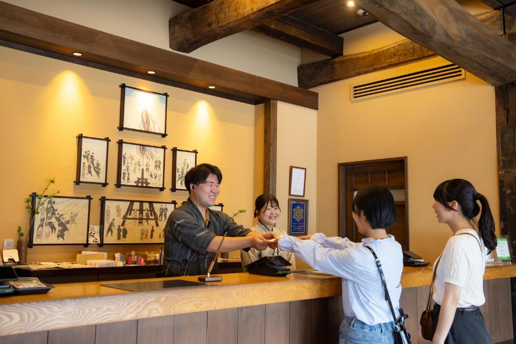 un groupe de personnes debout autour d'un comptoir dans un bar dans l'établissement Onyado Yuinosho, Shirakawago, à Shirakawa-gō 93 autres photos