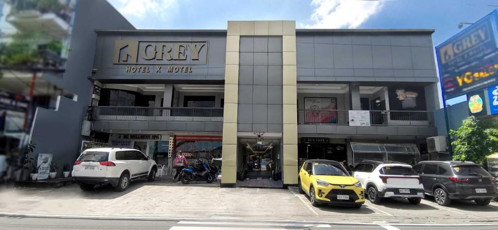 un edificio con auto parcheggiate in un parcheggio di Dancenter Airport Hotel - Grey Hotel a Santol