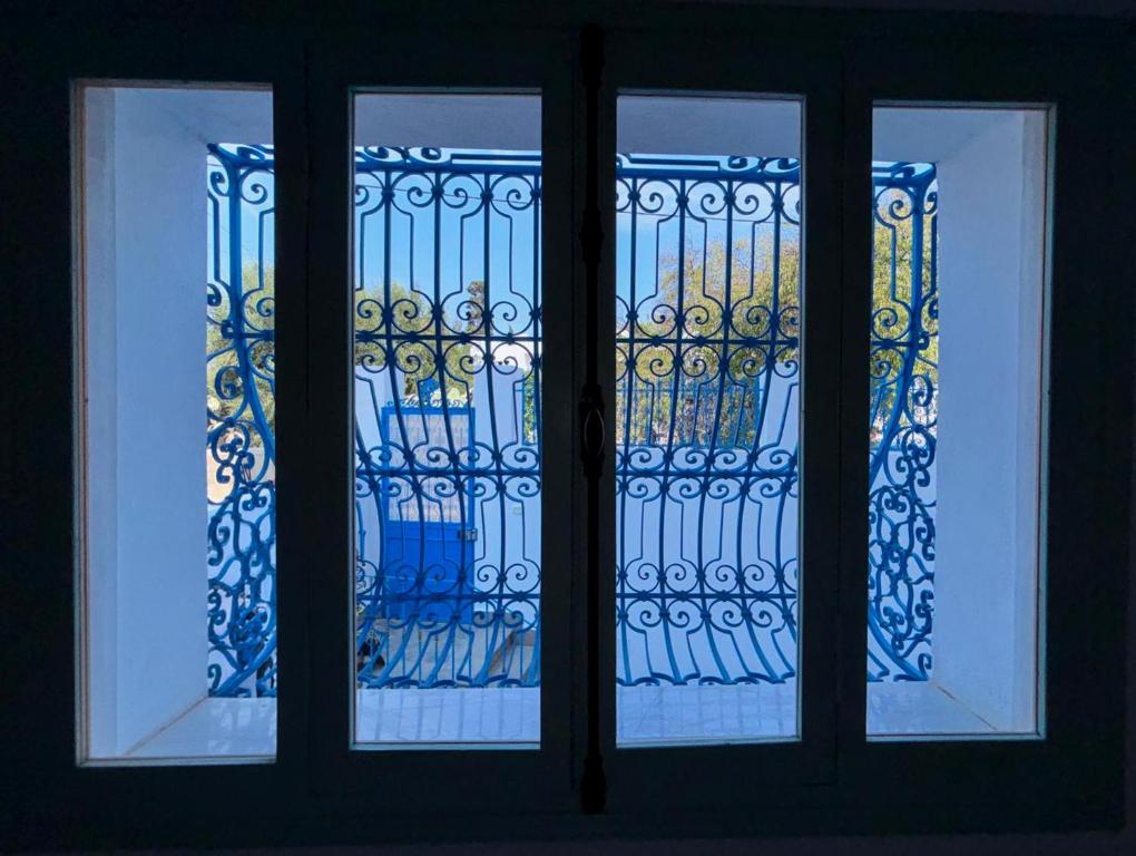 Una ventana con vista a una valla detrás de ella. en Dar El Nour Corniche Hammamet, en Hammamet