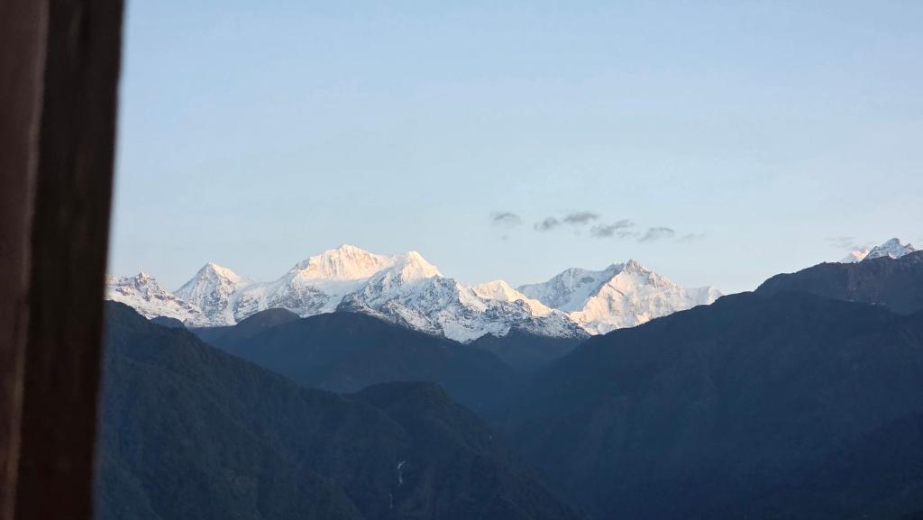a view of a mountain range with snow capped mountains at Sikkimese Inn Pelling in Pelling