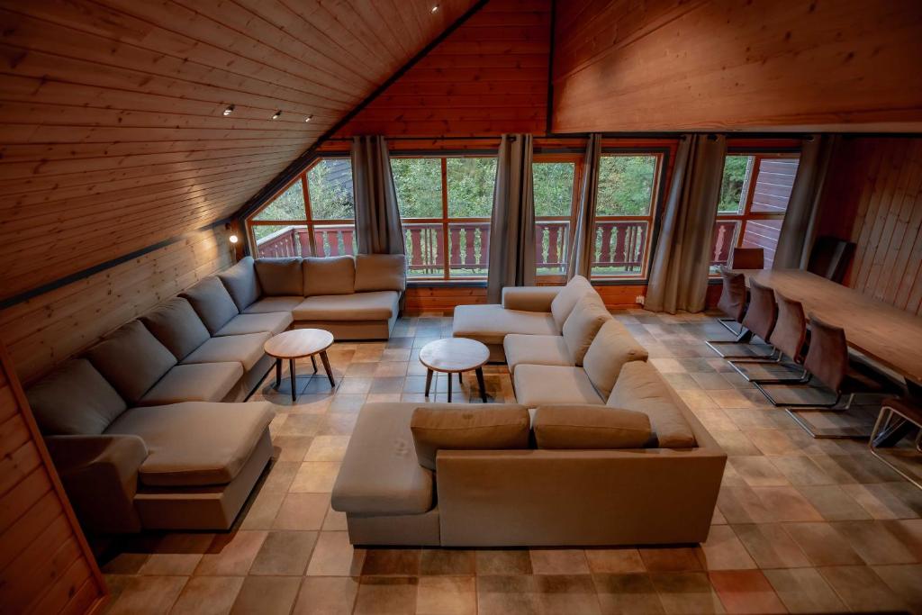 a living room with couches and tables and windows at Bakkebyvegen 7A in Trysil