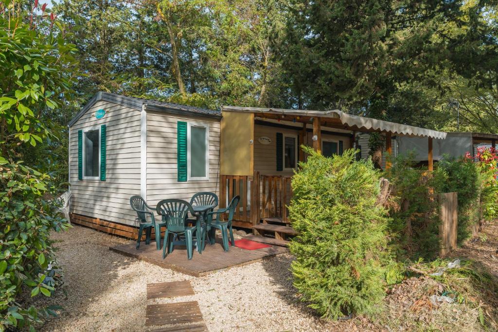 a tiny house with a table and chairs in the yard at Mobil-home in La Roque-dʼAnthéron