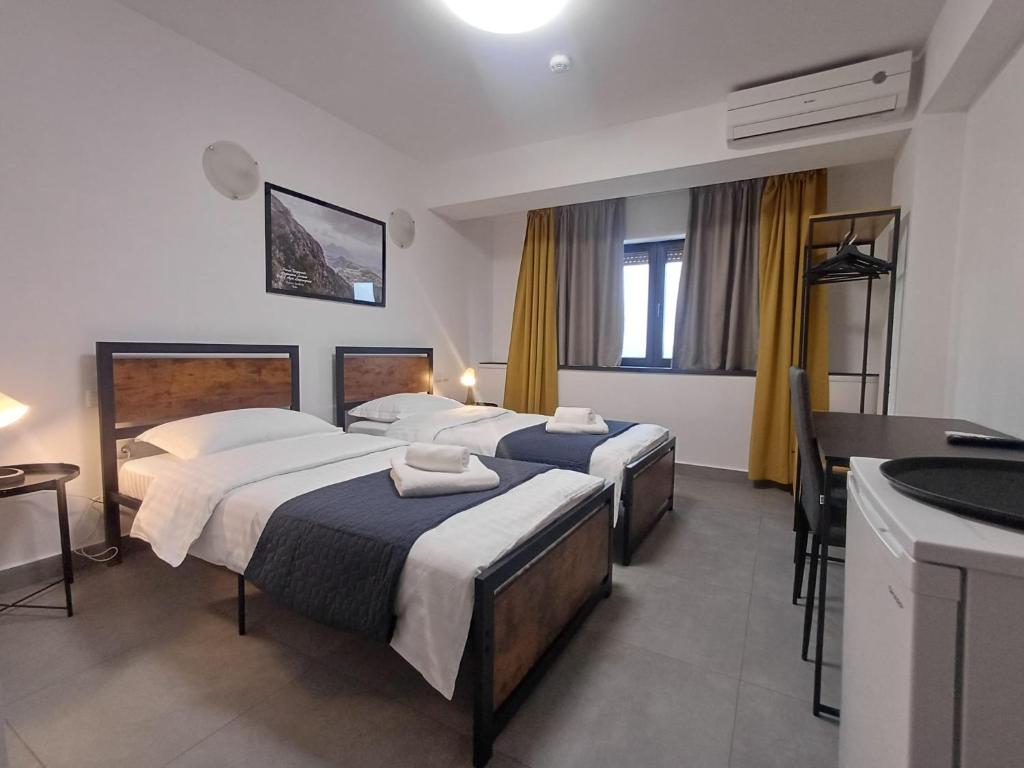 a hotel room with three beds and a sink at G Residence in Ploieşti