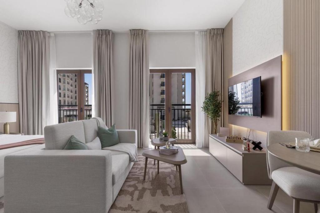 a living room with a couch and a room with a view at F1 Chic Yas Studio Park Discounts! Near Yas Golf in Yas Island