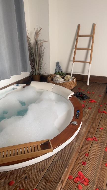 a hot tub in a room with a wooden floor at Cottage de pénélope in Lunéville