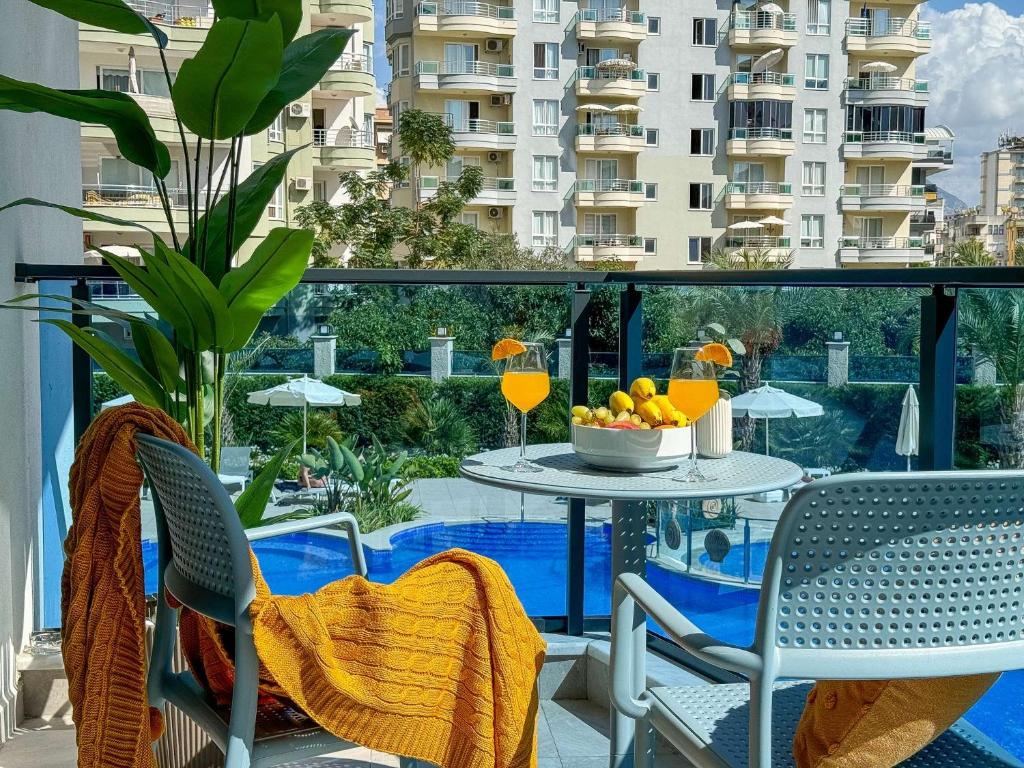 a balcony with a table with a bowl of fruit on it at Qoople Aria premium apartments in the center of Alanya in Alanya