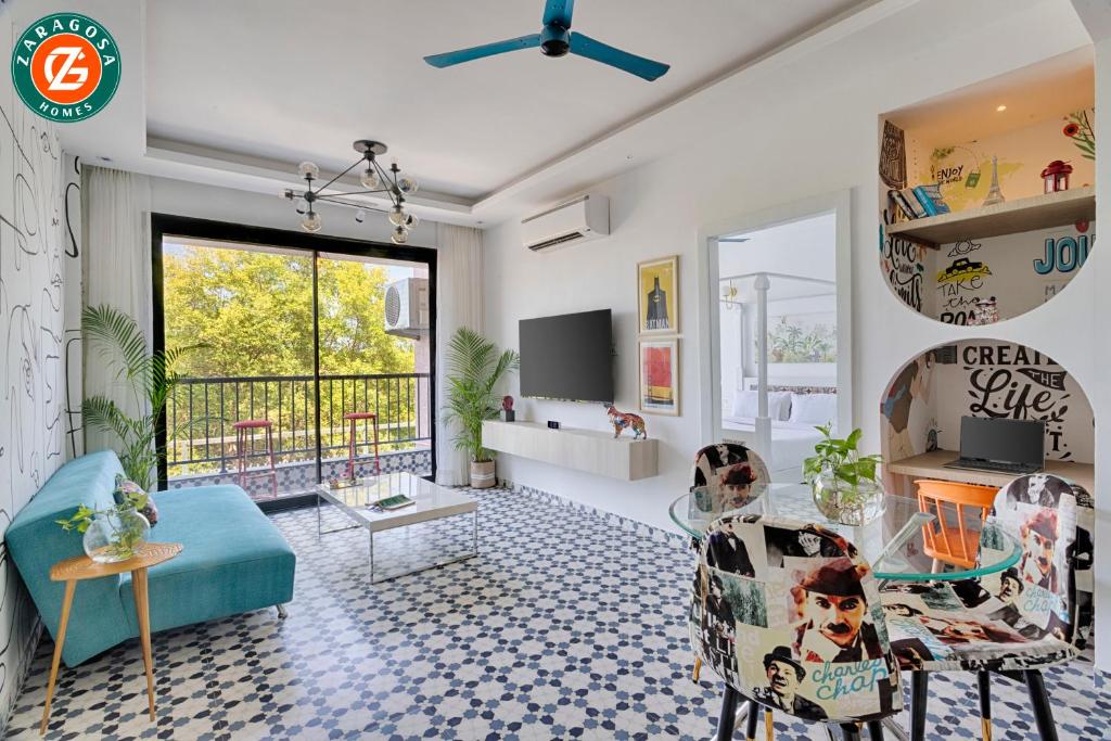 a living room with a glass table and chairs at The Blue Eyes by Leo Homes - 2BHK Flat in Candolim in Candolim