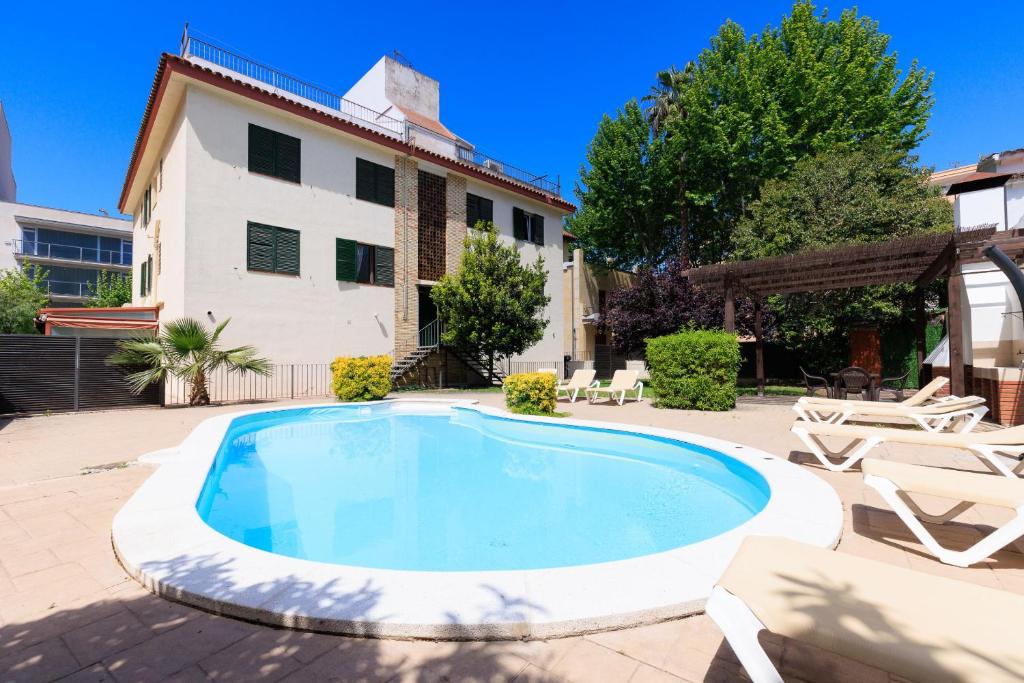 a swimming pool in front of a house at Apartaments QUEENS 2A in Salou