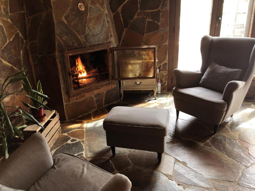 ein Wohnzimmer mit zwei Stühlen und einem Kamin in der Unterkunft Catalunya Casas Unique villa in Costa Maresme 27km to Barcelona! in Argentona