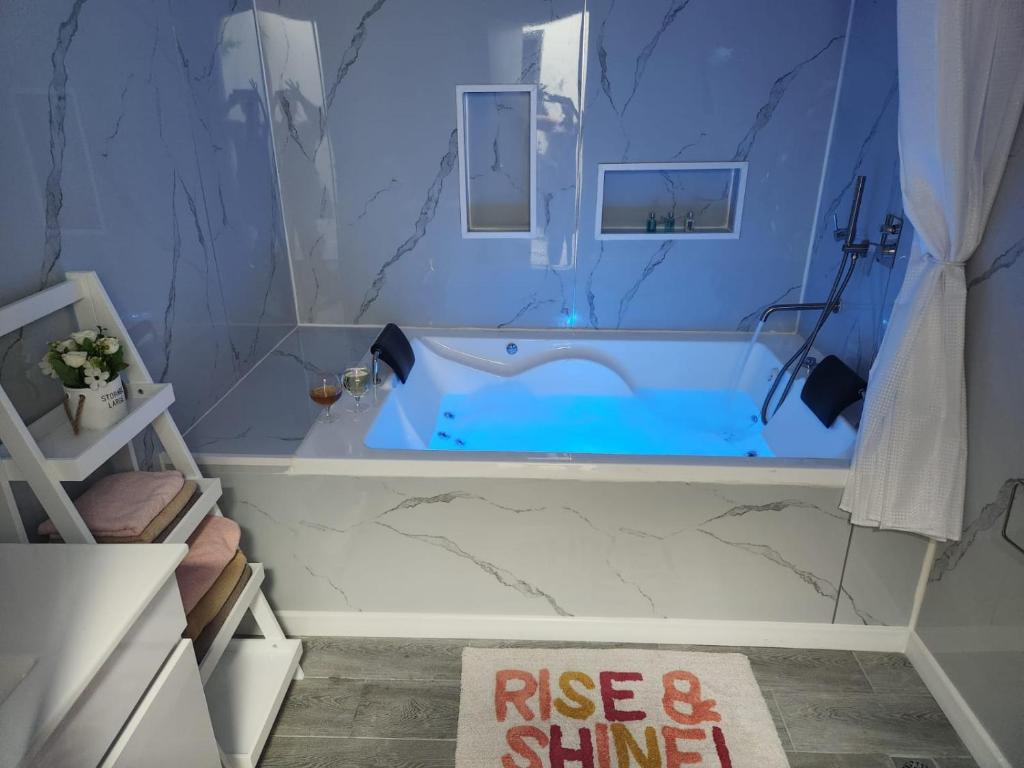 a bathroom with a blue tub with a sign that reads rise and shine at Tropicana in Amnon