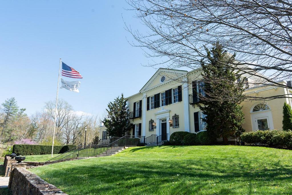 una casa blanca con una bandera americana en el patio en Airlie, en Warrenton