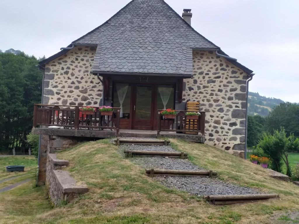 ein Steingebäude mit einem Weg, der zu einer Tür führt in der Unterkunft Chez Maurice et Sylvie in Laveissière