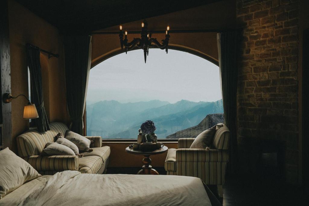 a bedroom with a window with a view of mountains at MiAmi Mountain Retreat in Bắc Yên