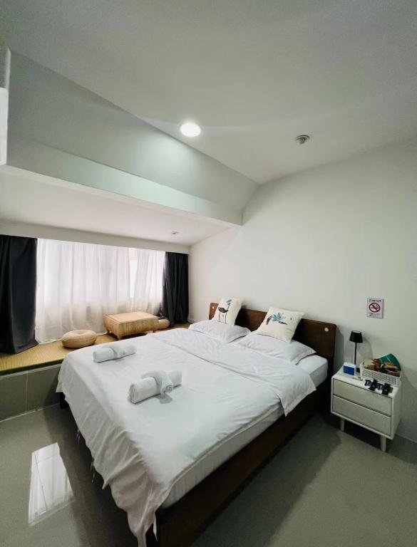 a bedroom with a large bed with two white towels at Tiger Homestay in Bangkok