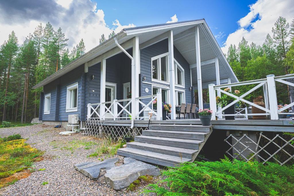una casa blu con portico e scale per raggiungerla di Hideout Villa Swan a Säräisniemi