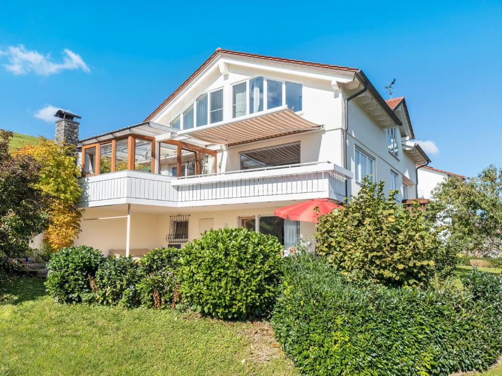 una grande casa bianca con cespugli di fronte di Am Alpenblick 5 a Lindau
