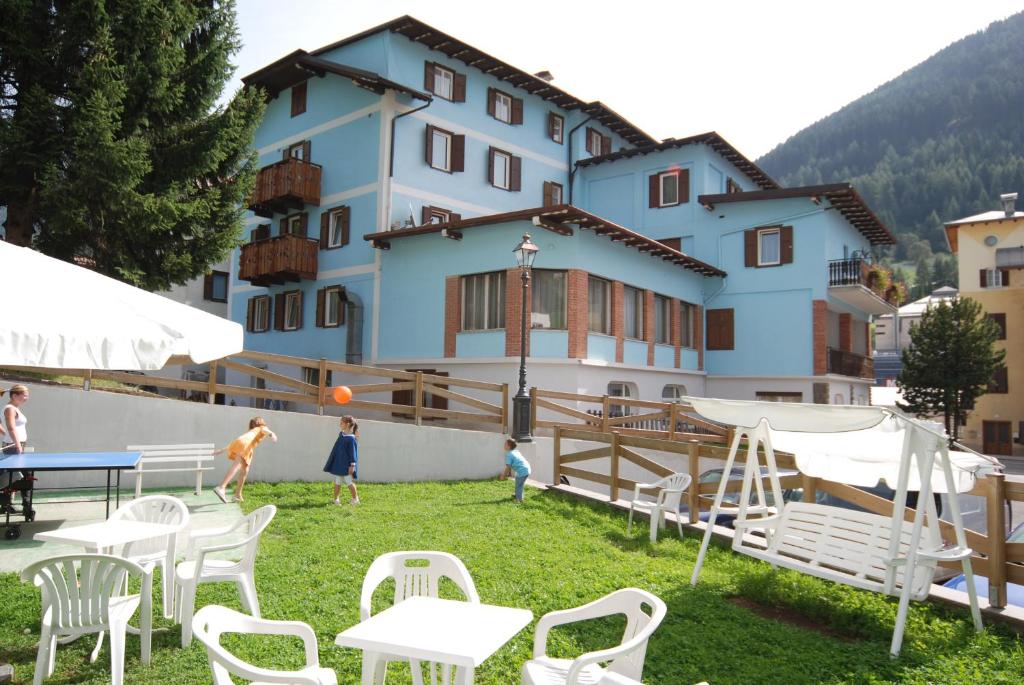 a group of people playing with a ball in front of a building at Hotel Ancora in Moena