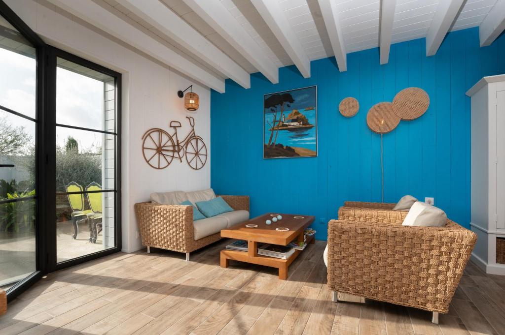 ein Wohnzimmer mit blauen Wänden und einer Couch und einem Tisch in der Unterkunft La Maison bleue Domainedecolomban in Carnac