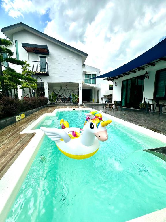 a pool with a unicorn float in the water at Stylish Villa Alma 18 Guests - Pool, KTV & BBQ in Simpang Ampat