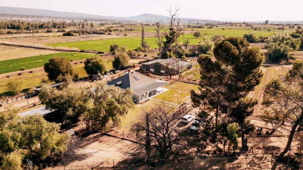 una vista aérea de una casa con un campo y árboles en Shama Guest Farm - A True Klein Karoo Farm Escape, en Oudtshoorn