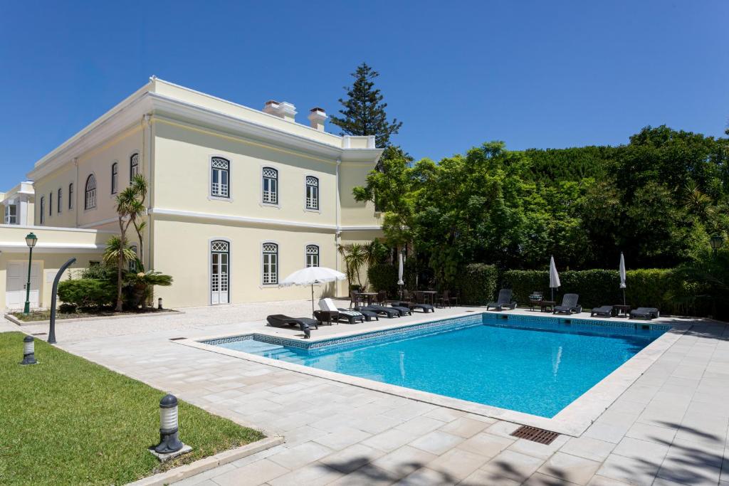 a swimming pool in front of a house at Royal Hideaway Estoril 2BR Pool Retreat in Estoril