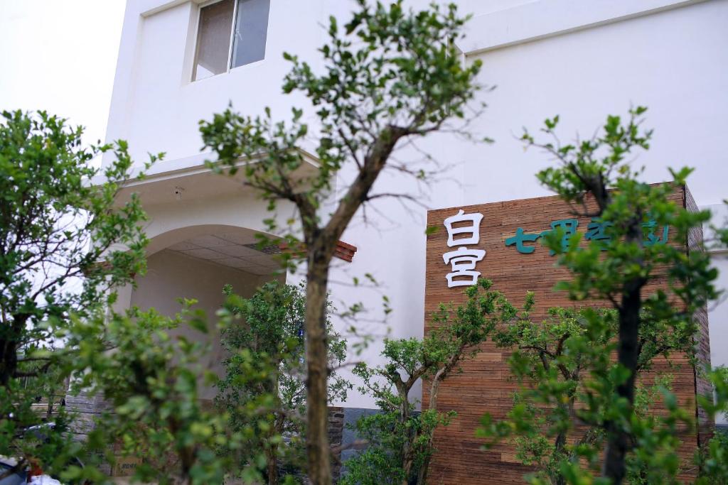 a building with a sign on the side of it at 白宮七哩香園民宿 in Hou-p'an-ts'un