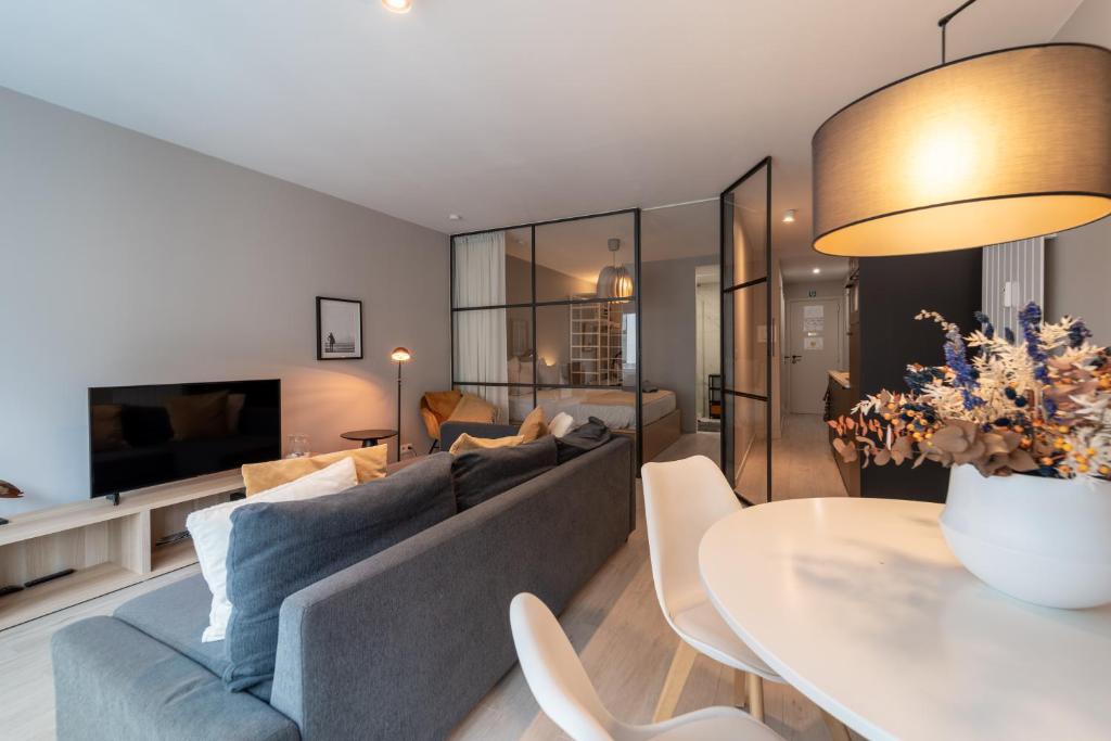 a living room with a couch and a table at Ostend Central Residence in Ostend
