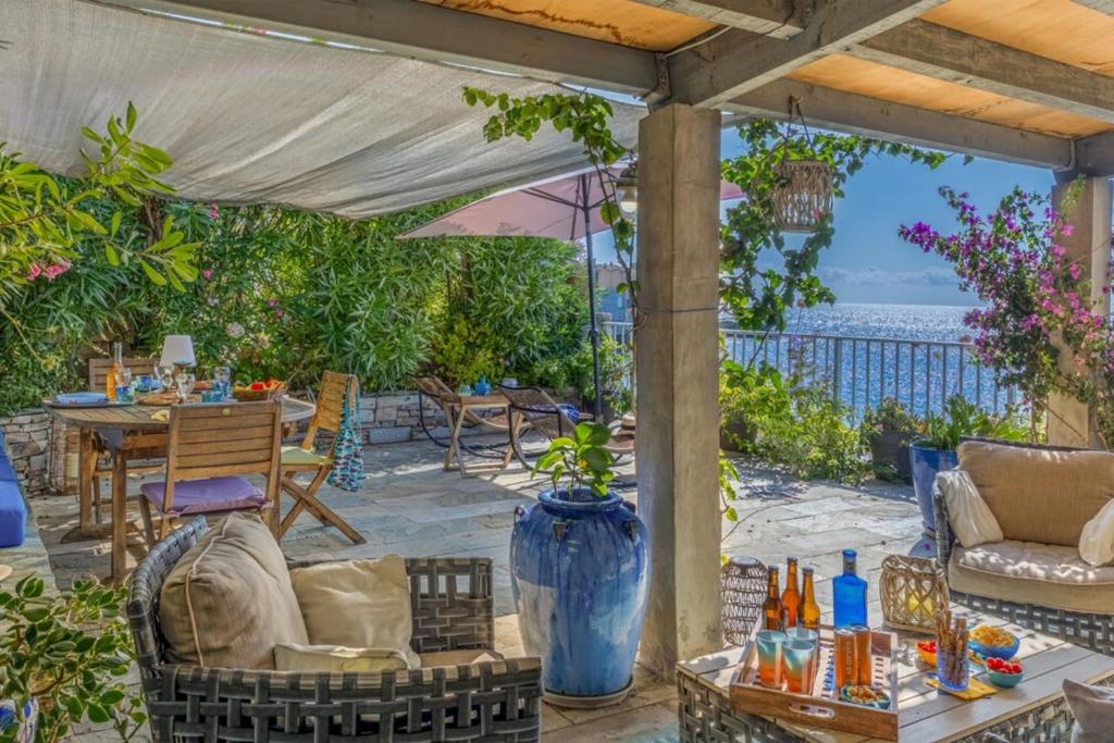 eine Terrasse mit Tisch und Stühlen und einem Sonnenschirm in der Unterkunft Casetta Ricci - Les Azedarachs II in Erbalunga
