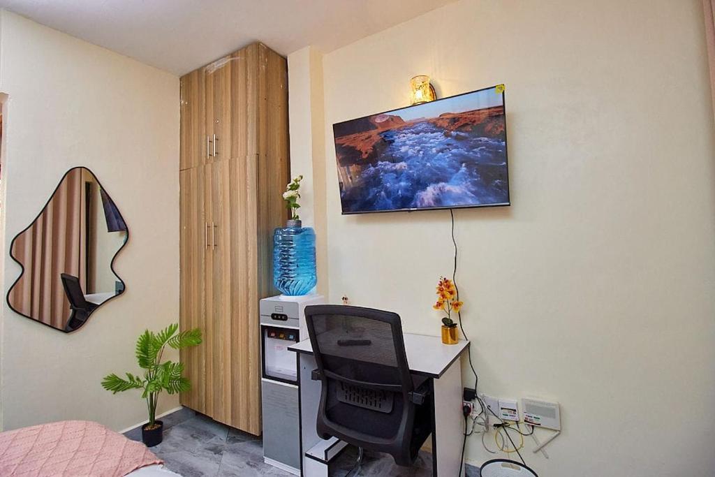 Habitación con escritorio y ordenador en la pared. en Happy Crest Airbnbs, en Nairobi