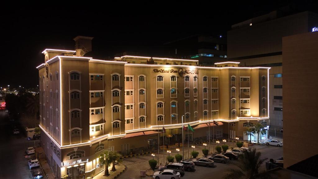 アル・コバールにあるوردة الرمال للأجنحة الفندقيةの夜にライトが点灯する大きな建物