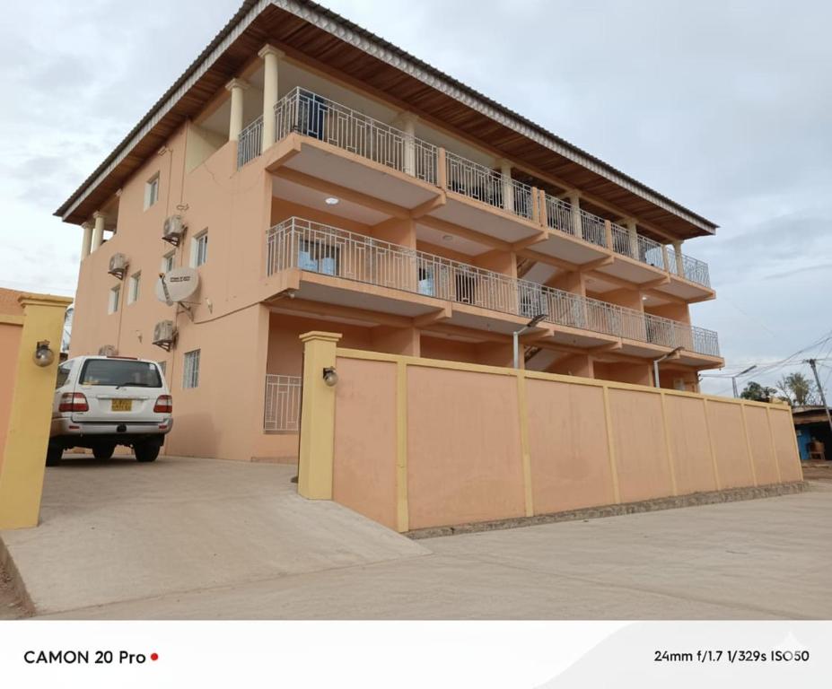 a building with a van parked in front of it at Residhome ACACIA in Moanda