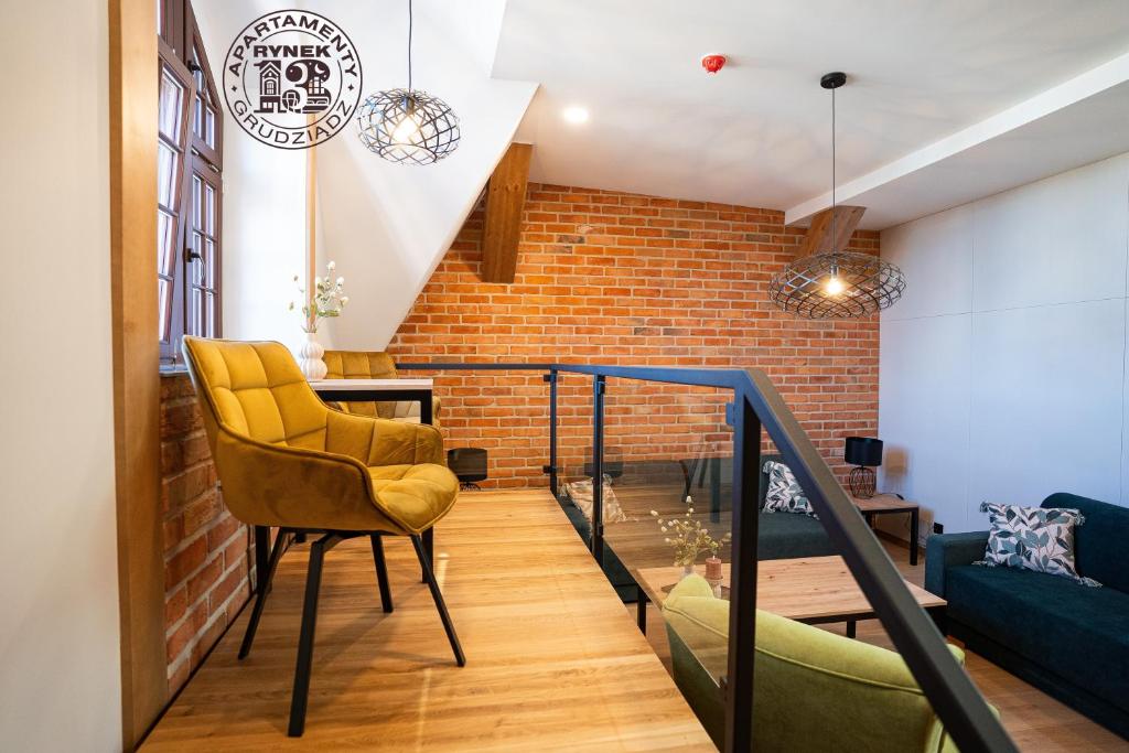 a room with a staircase and a brick wall at Apartamenty Rynek 13 in Grudziądz