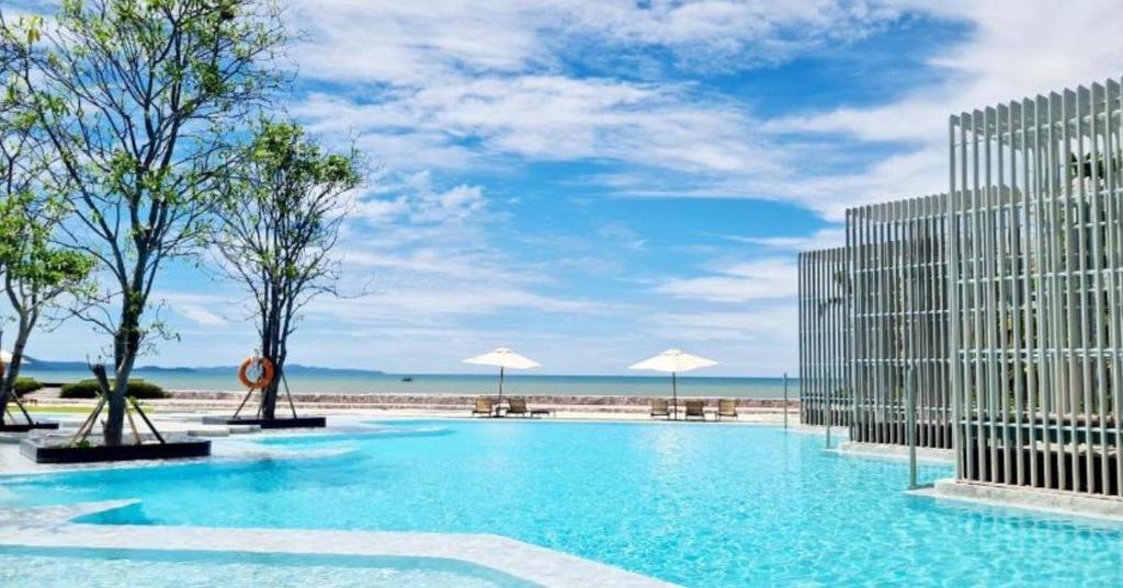 a large swimming pool in front of a building at 2 Bedroom Condo R268 Veranda Pattaya Beachfront in Na Jomtien