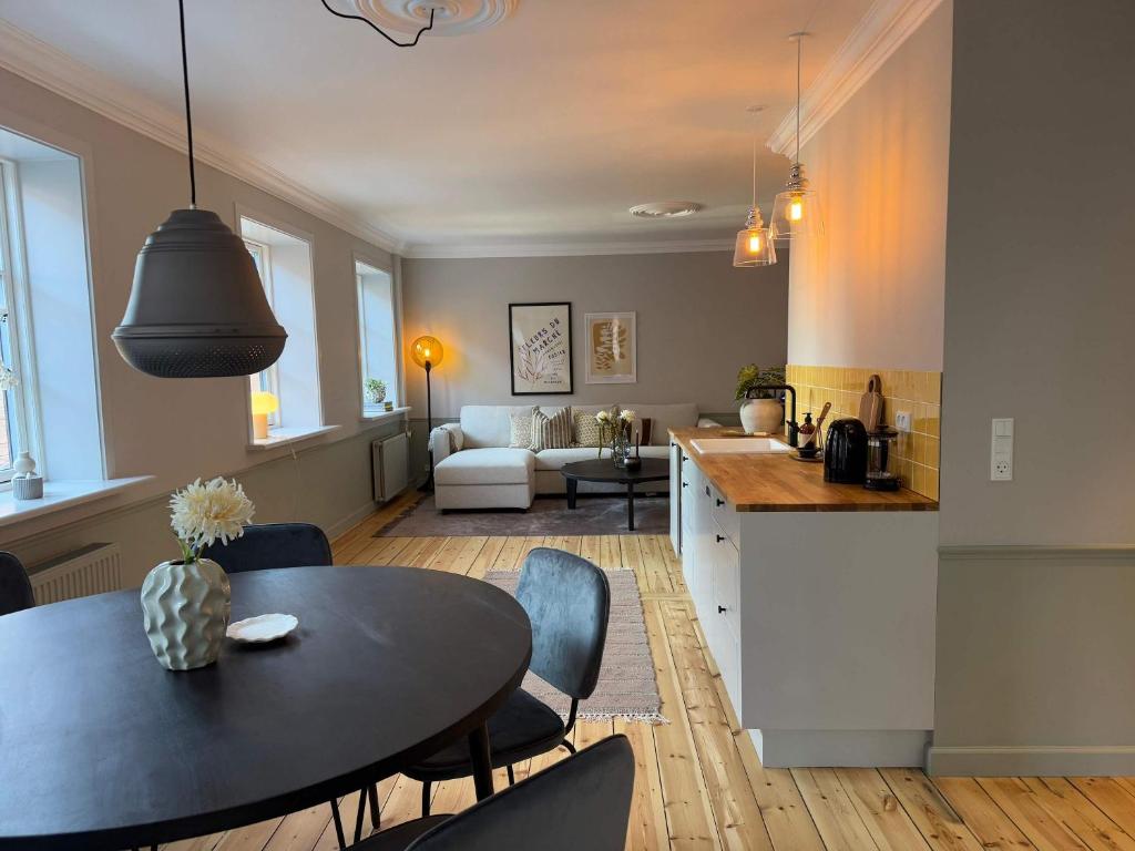 Una cocina y una sala de estar con mesa y sillas. en Upscale 3BR Apartment in City Center, en Copenhague