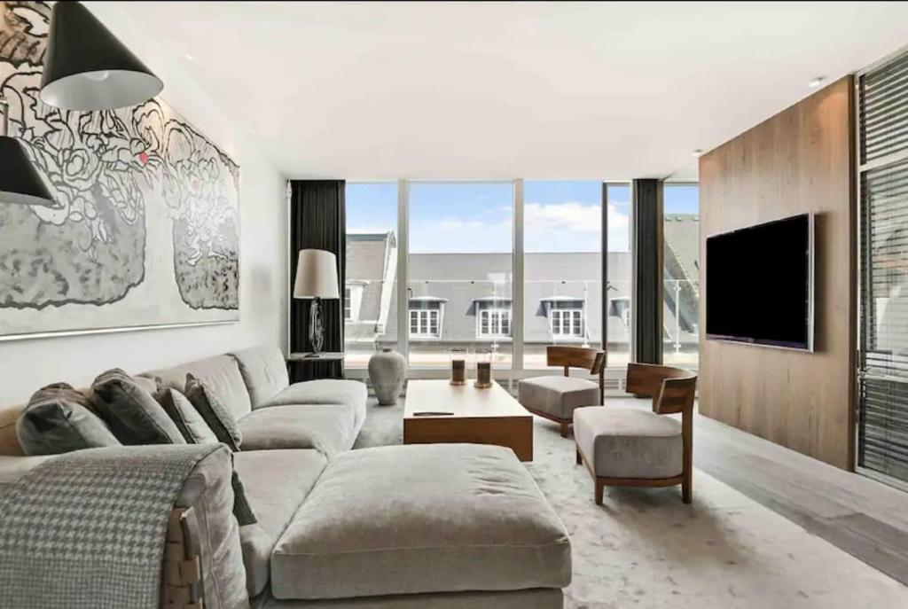 a living room with a couch and a tv at Elite Penthouse prime location in Copenhagen