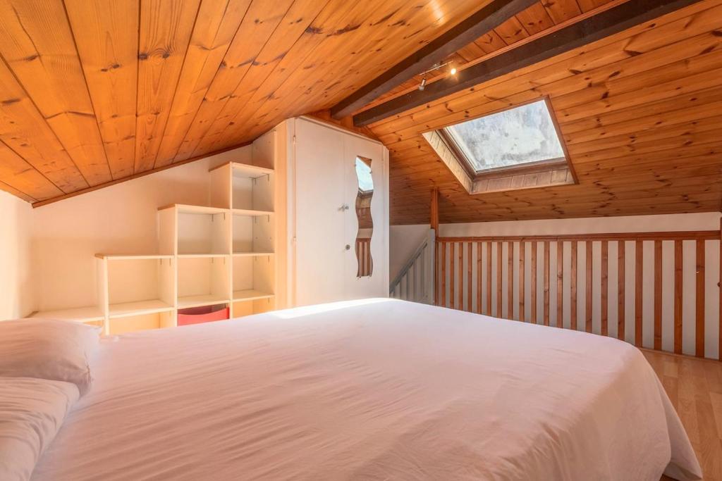 1 dormitorio con cama blanca en el techo de madera en Le Central, en Thonon-les-Bains