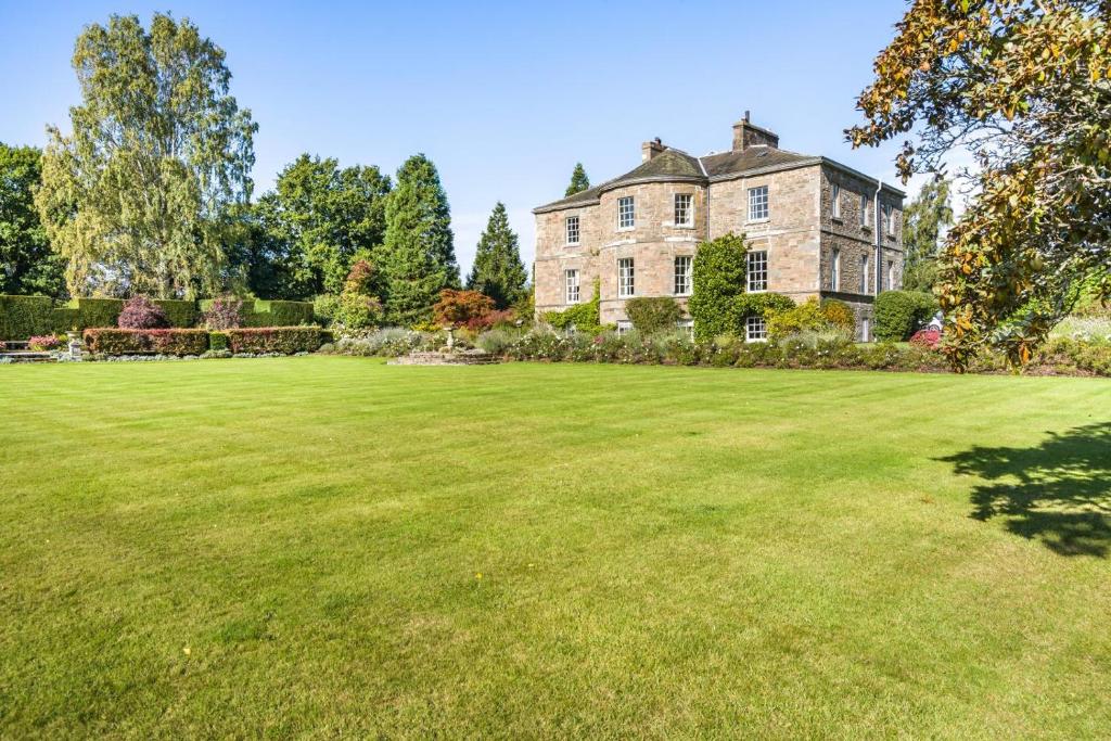 a large grass field in front of a large house at 5 Bed in Errol oc-t33381 in Errol