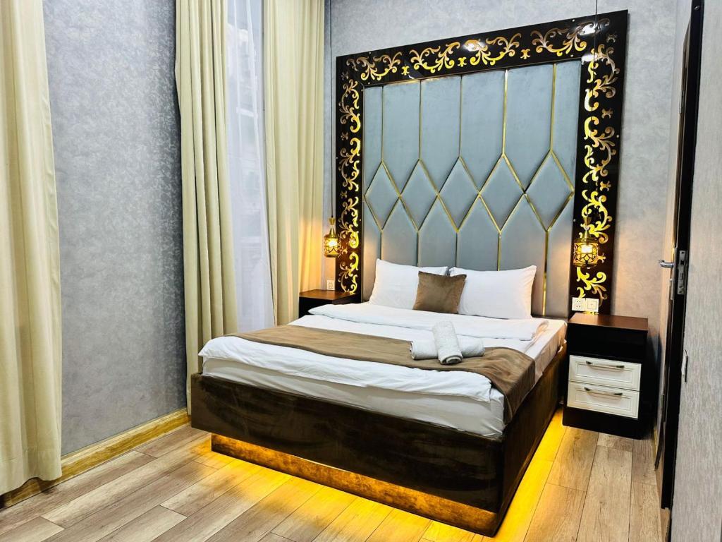 1 dormitorio con 1 cama con cabecero grande en City Inn Boutique Hotel, en Baku