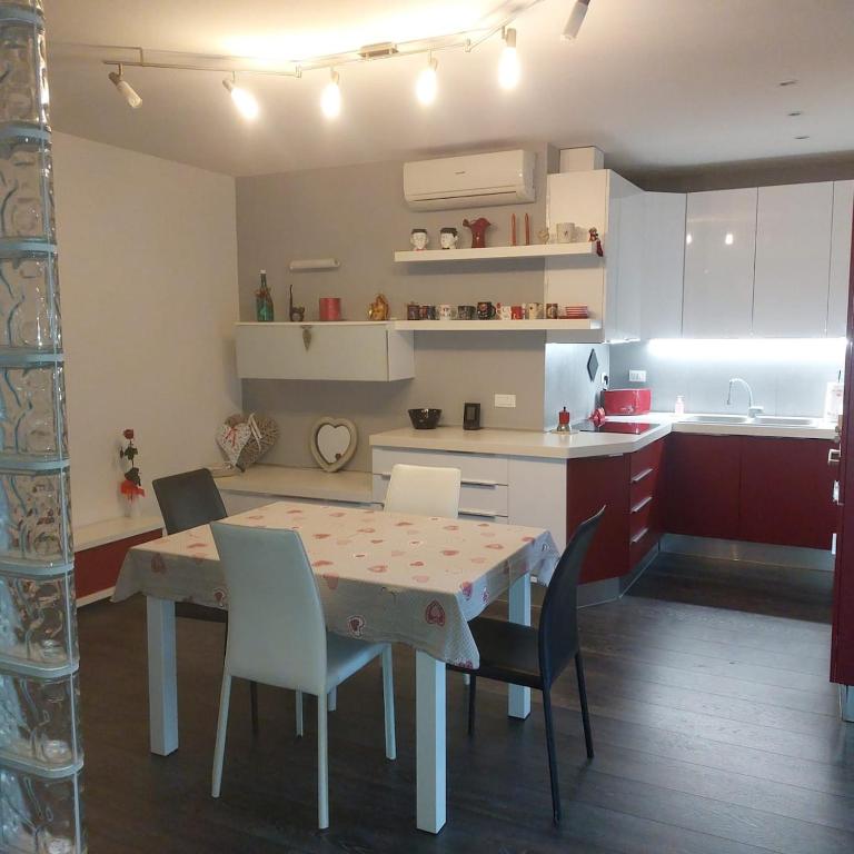 a kitchen with a table and chairs in a room at Appartamento Guido in Monfalcone