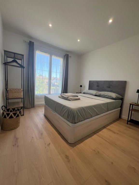 a bedroom with a large bed and a large window at Entre prairies et ciel bleu chez Nicolas ! in Mauchamps