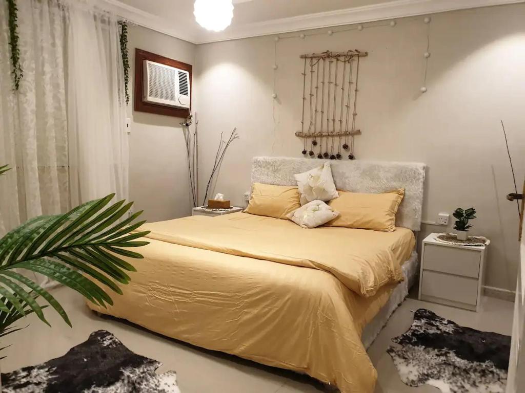 a bedroom with a large bed with yellow sheets at Mall of Islamabad Signature Apartments-F7 in Islamabad