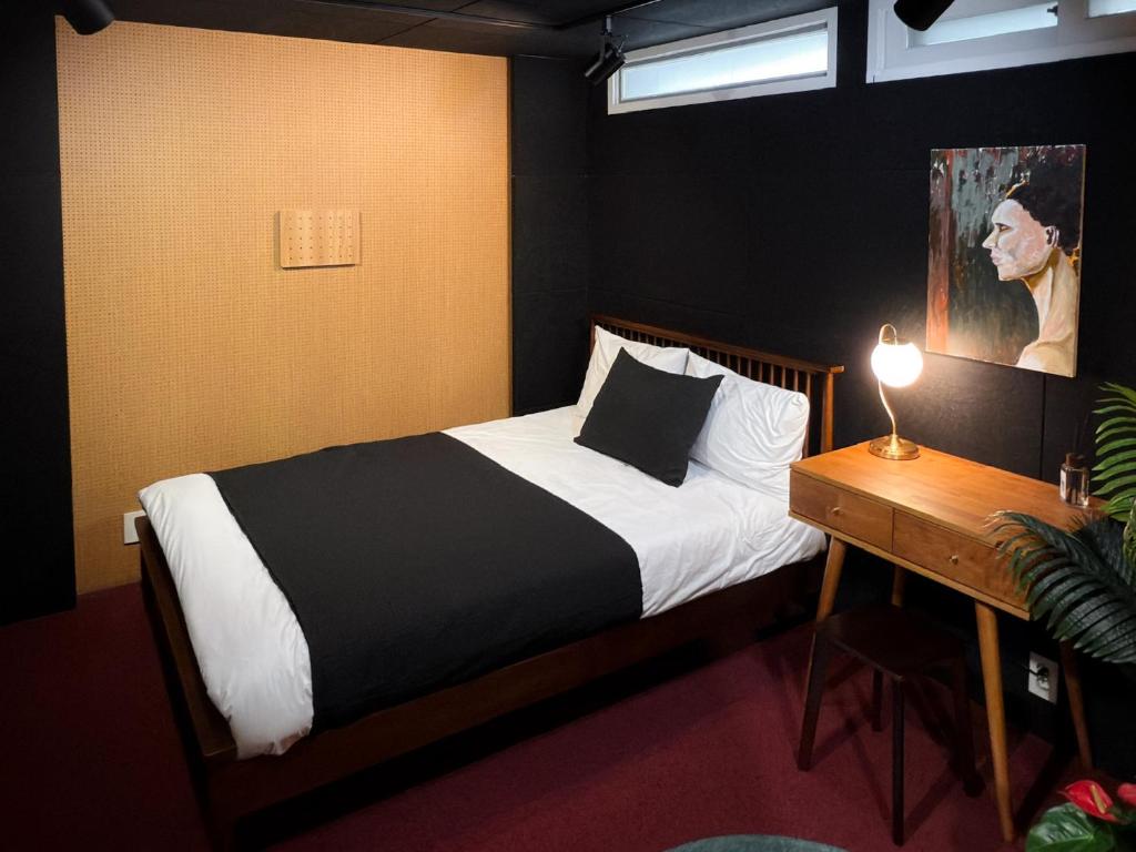 Un dormitorio con una cama y una mesa con una lámpara. en 명동, 남대문 7분! 2층 복층 2룸 하우스, en Seúl