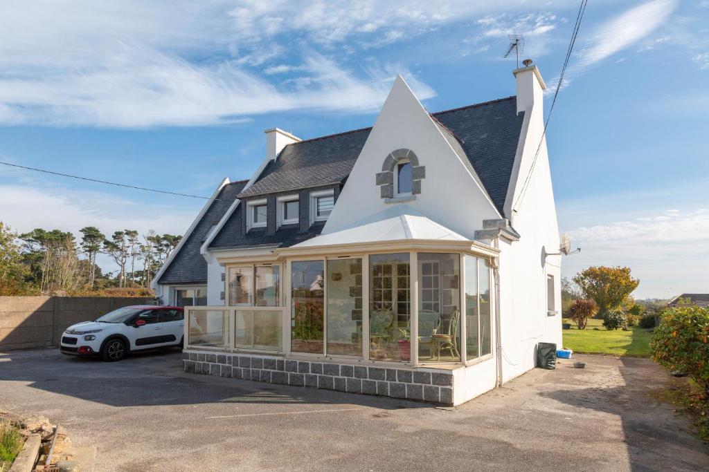 a house with a conservatory with a roof at Les Hortensias Entre Terre Et Mer in Plogoff