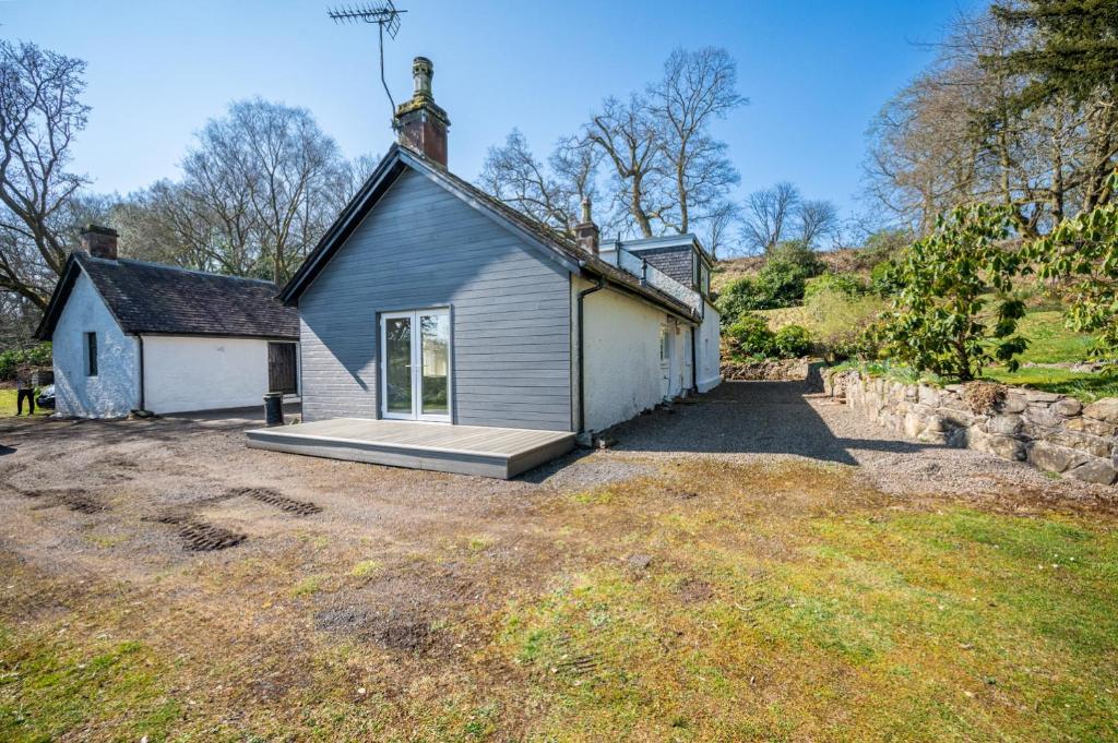una pequeña casa con un porche en un campo en The Stables Cottage, Beattock, Moffat, en Beattock