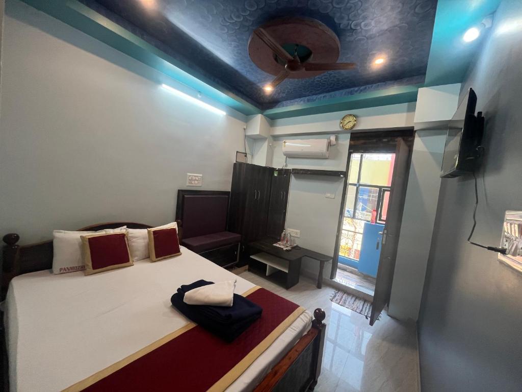 Una pequeña habitación con una cama y una ventana. en Panmozhi residency, en Tiruvannāmalai