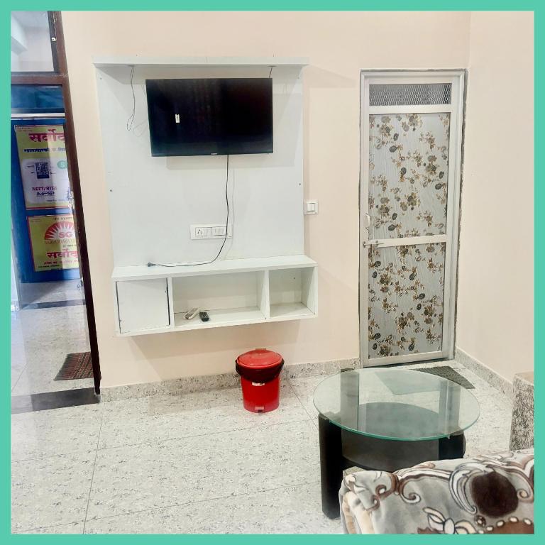 a living room with a tv and a glass table at Hotel Khatoo Shyam House in Khātu