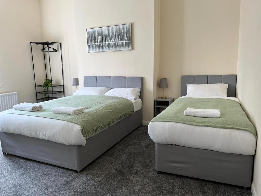 a bedroom with two beds and a mirror at Bewick Apartments in Newcastle upon Tyne