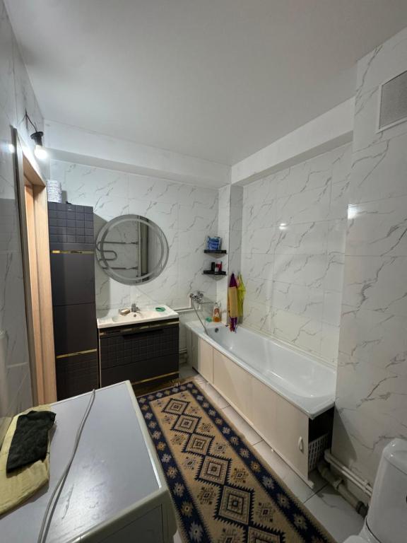 ein weißes Badezimmer mit Badewanne und Waschbecken in der Unterkunft 3х комнатная квартира in Öskemen