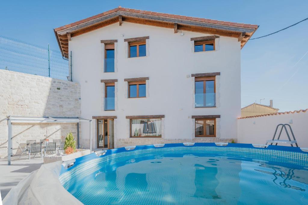 a villa with a swimming pool in front of a house at Lagar Del Altillo-Revilla Vallejer in Revilla-Vallegera