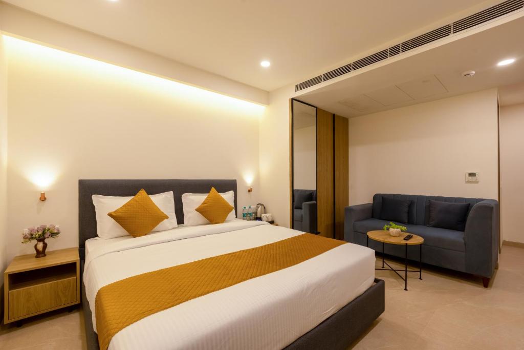 a hotel room with a bed and a couch at Limewood Signature - Golf Course Road in Gurgaon